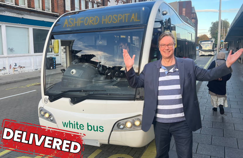 Jonathan Lord MP Standing Outside a White Bus