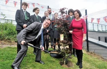 Jonathan planting a tree at a local school